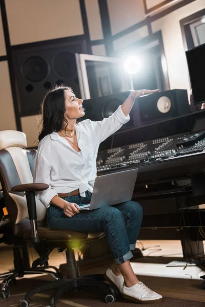 Atractivo productor de sonido haciendo gestos mientras trabajaba en un estudio de grabación - foto de stock