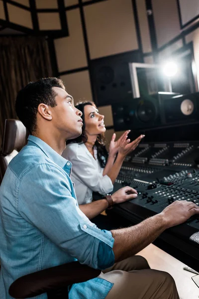 Messa a fuoco selettiva dei produttori di suoni che lavorano alla console di miscelazione in studio di registrazione — Foto stock