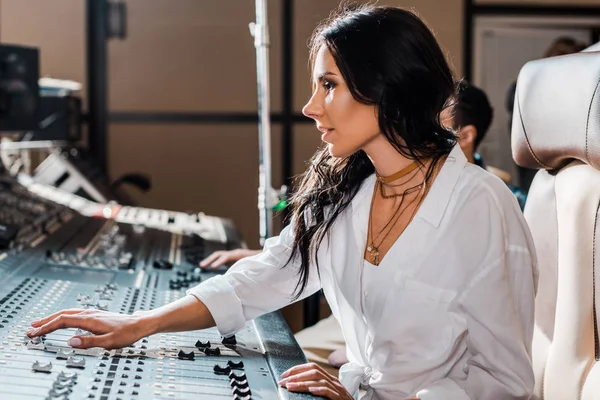 Magnifique producteur de son concentré travaillant à la console de mixage en studio d'enregistrement — Photo de stock