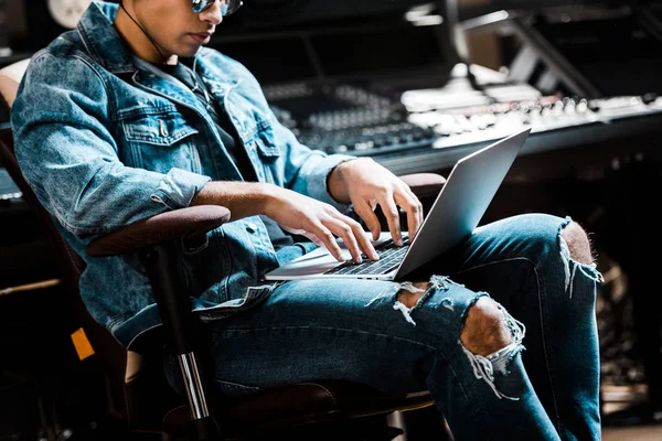 Produtor de som de raça mista concentrado usando laptop digital em estúdio de gravação — Fotografia de Stock