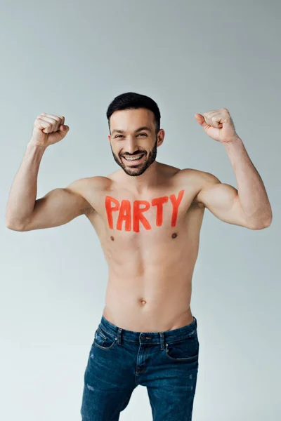 Smiling shirtless man with inscription on body showing yes gesture on grey — Stock Photo