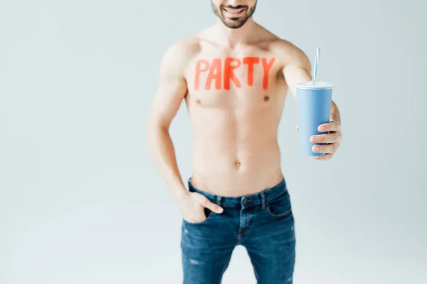 Vista recortada del hombre sin camisa con inscripción en el cuerpo sosteniendo bebida aislada en gris — Stock Photo