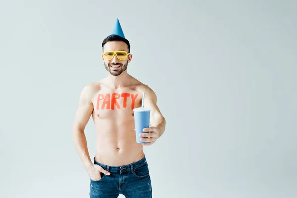 Shirtless man with inscription on body holding beverage isolated on grey — Stock Photo