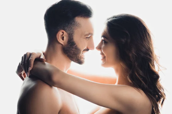 Side view of nude smiling couple embracing isolated on white — Stock Photo