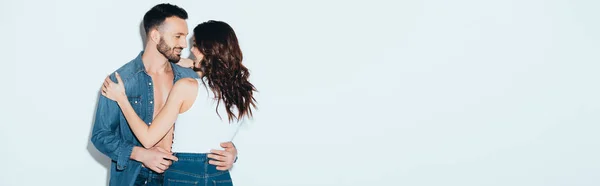 Tiro panorâmico de casal sorridente abraçando em cinza — Fotografia de Stock