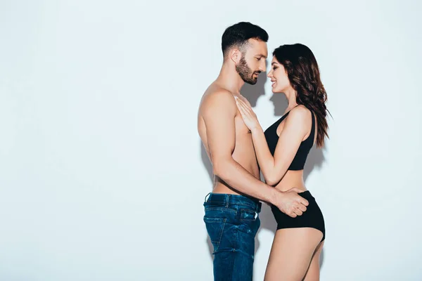 Vue latérale du couple amoureux embrassant sur gris — Photo de stock