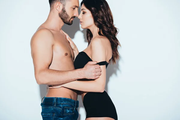 Vue latérale du couple amoureux embrassant sur gris — Photo de stock