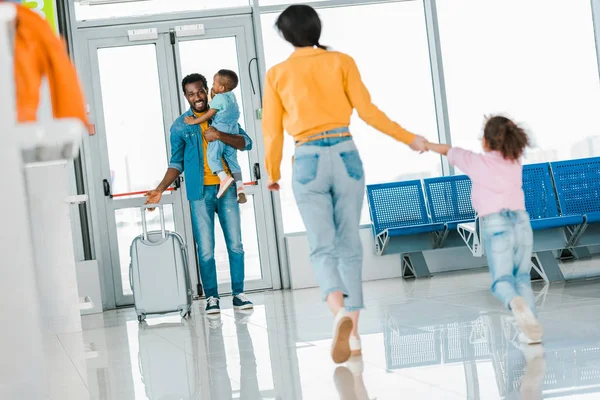 Selective focus of happy african american family meeting in airport — Stock Photo