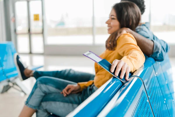 Enfoque selectivo de billete de avión y pasaporte en la mano de la mujer en el aeropuerto - foto de stock