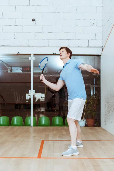 Deportista de polo azul jugando squash en cancha de cuatro paredes — Stock Photo