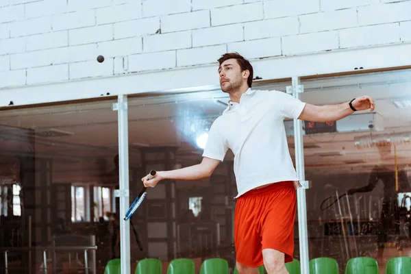 Esportista em camisa de pólo branco jogando squash em quadra de quatro paredes — Fotografia de Stock