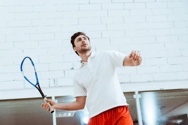 Sportsman in polo bianca giocare a squash in campo a quattro pareti — Foto stock