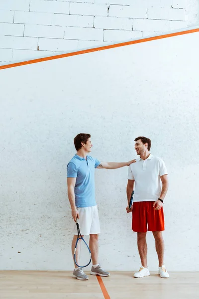 Full length view of squash player putting hand on shoulder of friend — Stock Photo