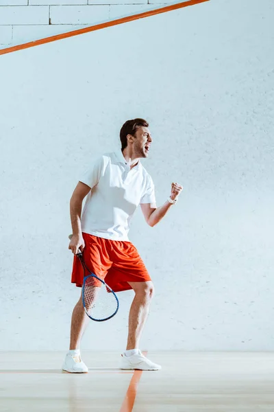 Vue complète du joueur de squash heureux avec raquette montrant un geste oui — Photo de stock