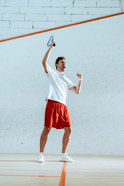 Vista completa del jugador de squash feliz con raqueta que muestra sí gesto — Stock Photo