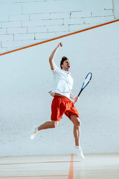 Visão completa do jogador de squash feliz com raquete mostrando sim gesto — Fotografia de Stock