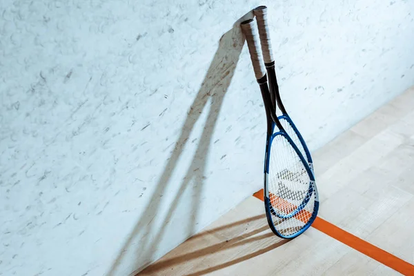 Due racchette da squash su pavimento in legno in corte a quattro pareti — Foto stock