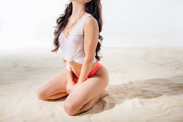 Abgeschnittene Ansicht einer sexy jungen Frau, die am Strand mit Kopierplatz sitzt und posiert — Stockfoto