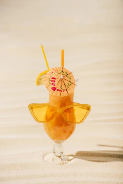 Cocktail laranja com óculos de sol e guarda-chuva na praia de areia — Fotografia de Stock