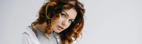 Panoramic shot of pretty girl with red hair looking at camera on white — Stock Photo