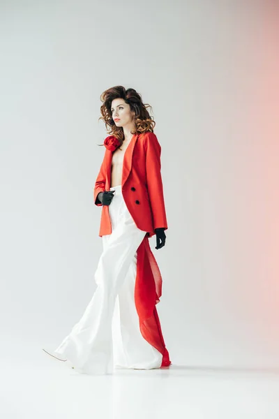Красивая и стильная рыжеволосая женщина, ходящая в сером с красным — стоковое фото