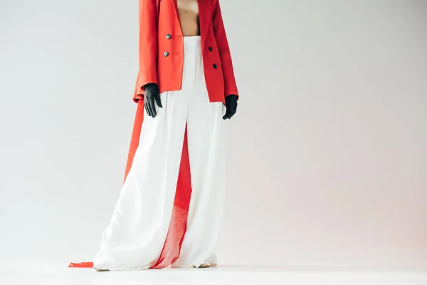 Cropped view of stylish young woman standing on grey — Stock Photo