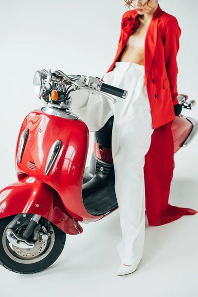 Vista recortada de la mujer joven con estilo sentado en la motocicleta roja en blanco - foto de stock