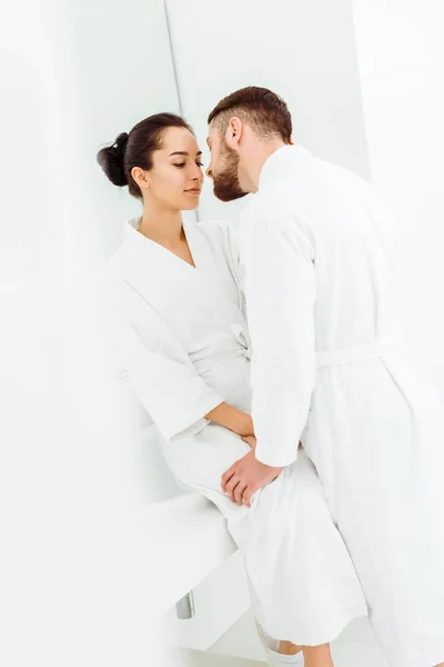 Selective focus of bearded man standing near attractive woman in bathrobe — Stock Photo