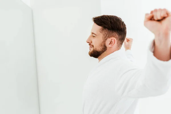 Счастливый бородатый мужчина растягивается после пробуждения в ванной комнате — стоковое фото