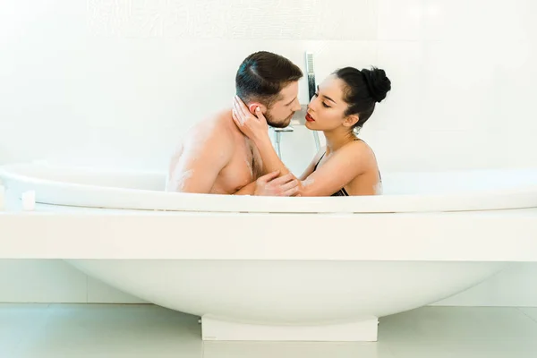 Brunetta donna toccare bello camicetta uomo in vasca da bagno — Foto stock