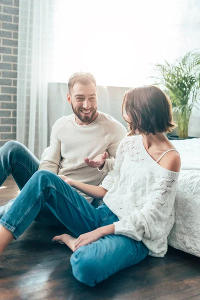 Homme barbu joyeux souriant tout en regardant la femme à la maison — Photo de stock