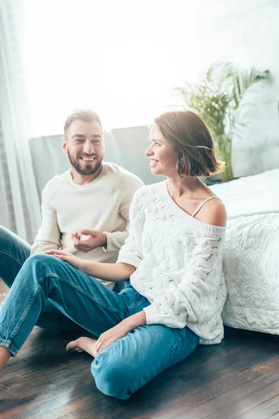 Cheerful bearded man gesturing while looking at woman at home — Stock Photo