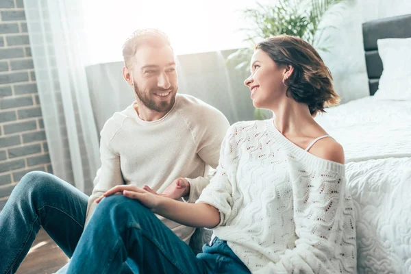 Cheerful brunette woman looking at handsome bearded at home — Stock Photo
