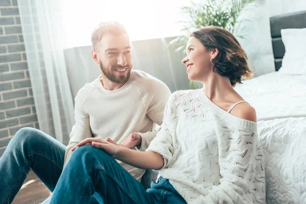 Femme brune gaie regardant beau barbu à la maison — Photo de stock