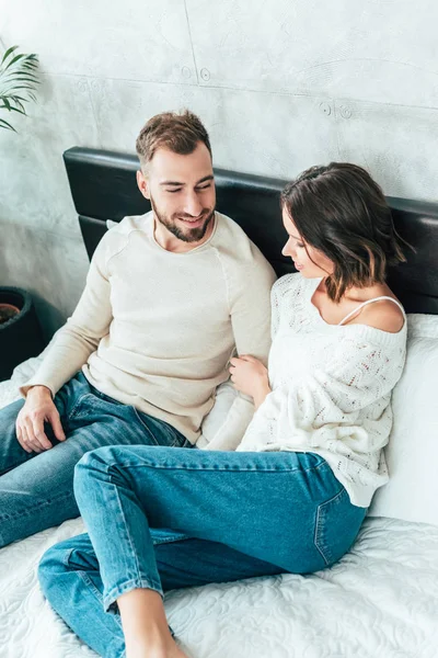 Overhead view of happy man looking at attractive woman lying on bed — Stock Photo