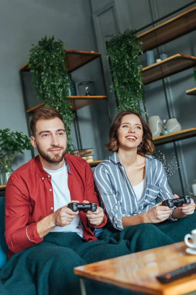 Selective focus of handsome man and happy woman playing video came in living room — Stock Photo