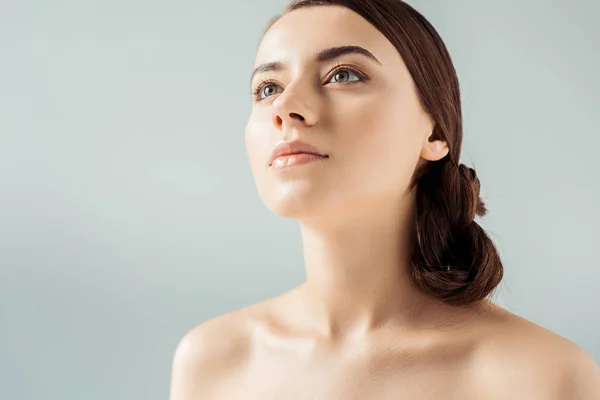 Mujer atractiva joven con labios brillantes y sombra de ojos dorada aislada en gris - foto de stock