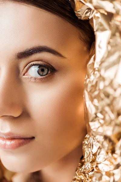 Cropped view of young attractive woman with shiny makeup near golden foil — Stock Photo