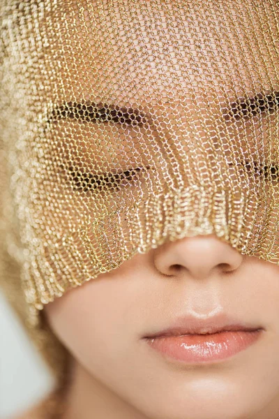 Close up de jovem mulher com olhos fechados, lábios brilhantes e pano dourado no rosto — Fotografia de Stock