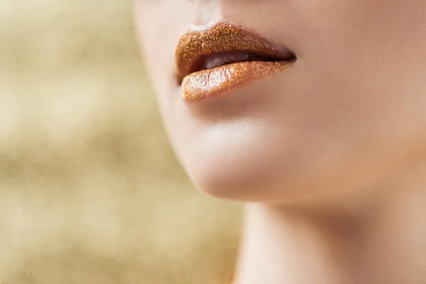 Vista cortada de mulher jovem com lábios dourados brilhantes — Fotografia de Stock