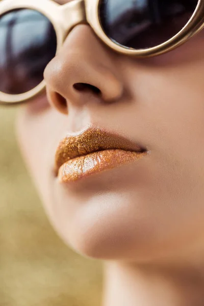 Молода красива жінка в сонцезахисних окулярах з блискучими золотими губами — стокове фото