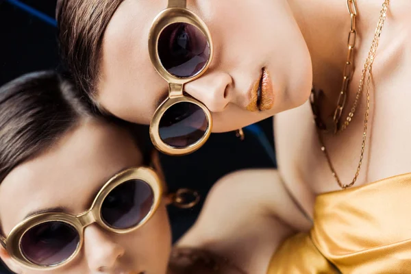 Молодая женщина в солнечных очках, золотые ожерелья лежат на зеркале — стоковое фото
