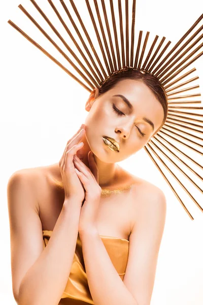 Joven hermosa mujer con los ojos cerrados, maquillaje dorado y accesorio en la cabeza aislado en blanco - foto de stock