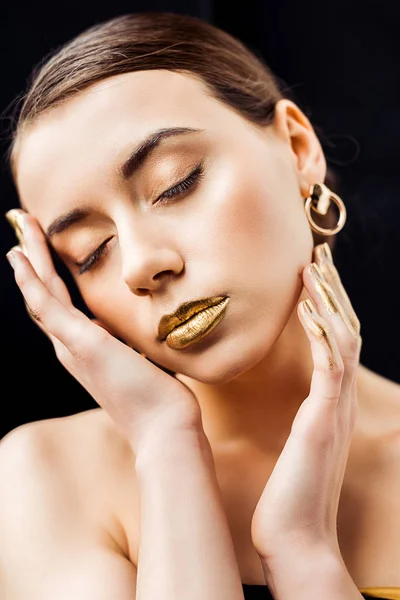 Young woman with golden makeup isolated on black — Stock Photo