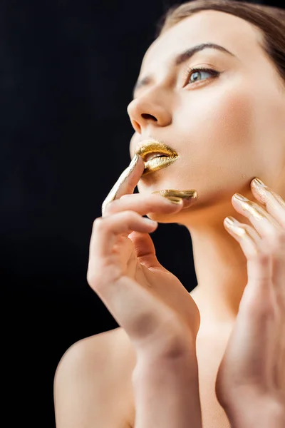 Young beautiful nude woman with golden makeup isolated on black — Stock Photo