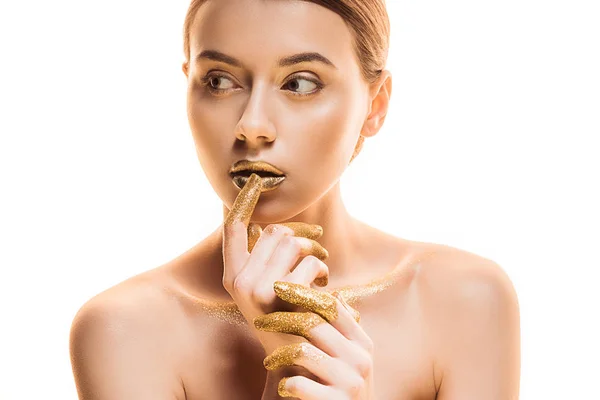 Молодая обнаженная красивая женщина с золотым макияжем и блестками на пальцах касающихся губ, изолированных на белом — стоковое фото