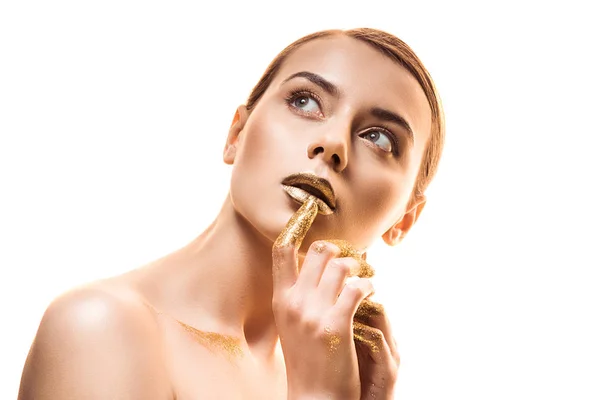 Молода оголена красива жінка з золотим макіяжем і блискітками на пальцях торкається губ ізольована на білому — стокове фото
