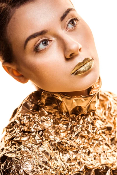 Jeune belle femme avec des lèvres dorées en feuille d'or regardant loin isolé sur blanc — Photo de stock
