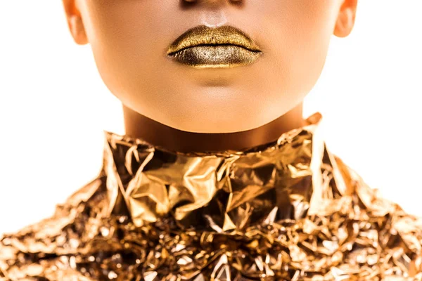 Vista recortada de mujer joven con labios dorados en lámina dorada aislada en blanco - foto de stock