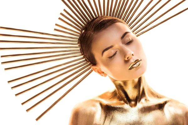 Giovane donna nuda dipinta in oro con accessorio sulla testa e occhi chiusi isolati su bianco — Foto stock